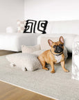 Brown french Bulldog sitting in Beige Teddy car travel dog bed from Le Noof in the living room