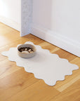 Le Noof's wavy dog bowl mat with bowl on the floor