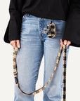 Woman holding brown checkered dog leash with matching poop bag holder