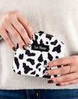 Cow print dog treat pouch in hands