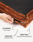 Brown fabric with waterproof inner lining and OEKO-TEX certification, held by a hand.
