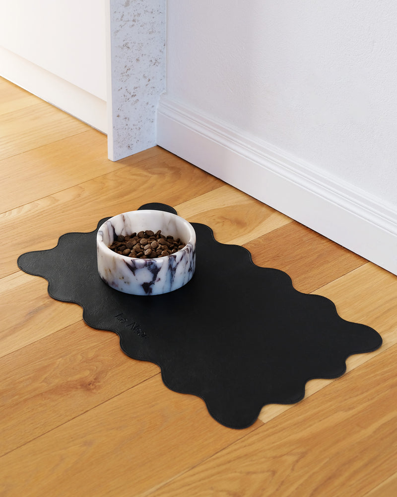 Le Noof's wavy reversible dog bowl mat on the floor with marble dog bowl