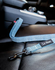 Light blue denim dog seatbelt buckled in car