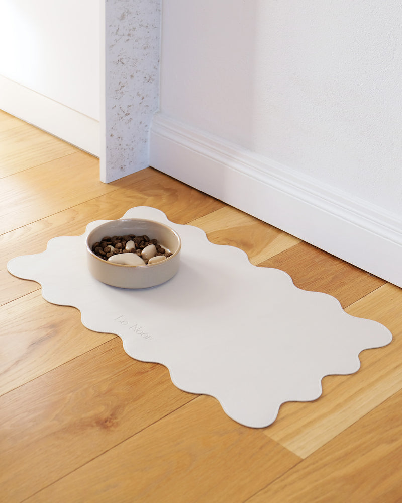 Le Noof's wavy dog bowl mat with bowl on the floor
