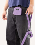 Lavender corduroy dog treat pouch clipped to a dog walker holding matching dog leash and poopbag holder