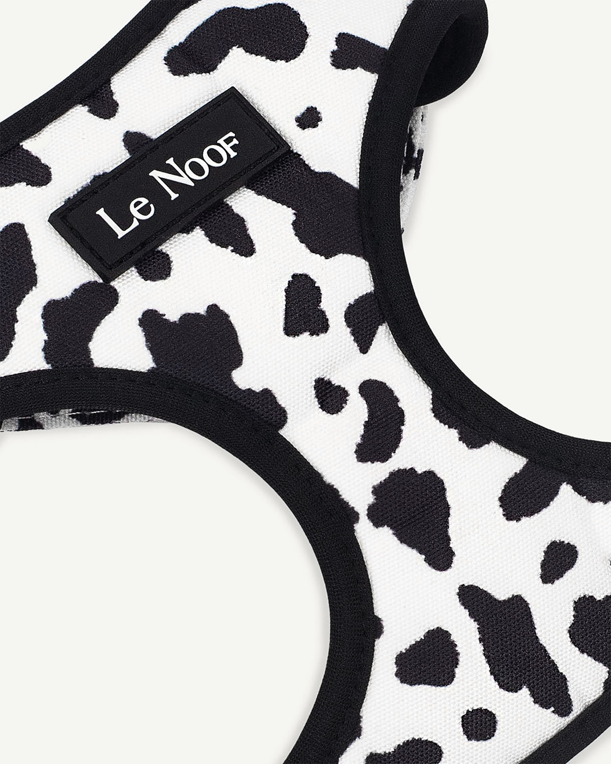 Cow print dog harness with Le Noof logo super closeup