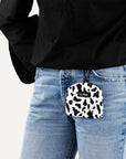Le Noof Cow print dog treat pouch worn by a women
