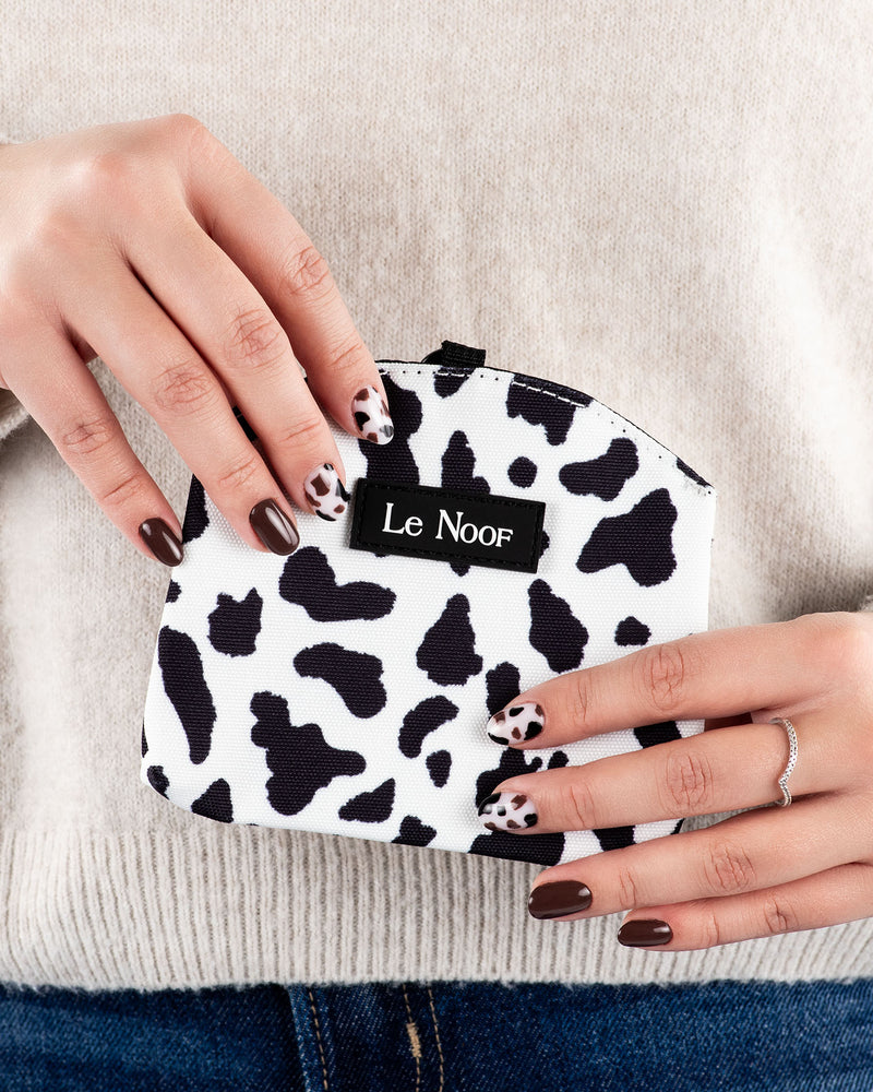 Cow print dog treat pouch in hands