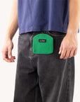 Green corduroy dog treat pouch clipped to dog owner