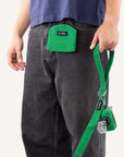 Green corduroy dog treat pouch worn by dog owner holding a matching dog leash