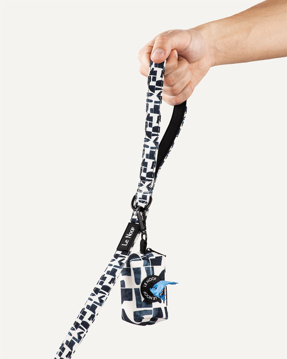 Geometric print dog leash with poop bag holder clipped to it with Le Noof logo